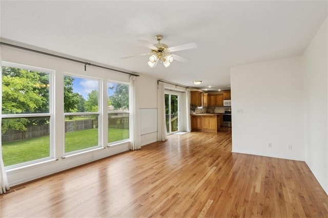 15050 W 145th St, Olathe, KS 66062 - unfurnished living room with a ceiling fan, light wood-style flooring, and baseboards