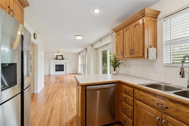 15050 W 145th St, Olathe, KS 66062 - kitchen with stainless steel appliances, a sink, decorative backsplash, light wood-style floors, and open floor plan