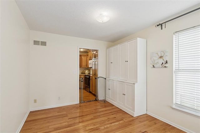 15050 W 145th St, Olathe, KS 66062 - unfurnished bedroom with light wood-style floors, baseboards, and multiple windows