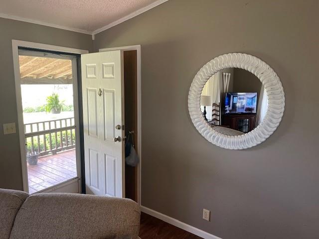 4691 New Hampshire Rd, Bronson, KS 66716 - entrance foyer with crown molding, dark wood-style floors, baseboards, and a textured ceiling
