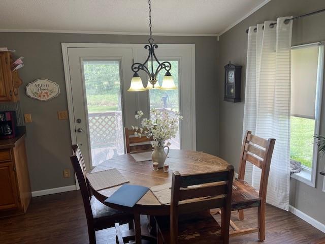 4691 New Hampshire Rd, Bronson, KS 66716 - dining space featuring baseboards, dark wood finished floors, a chandelier, and crown molding