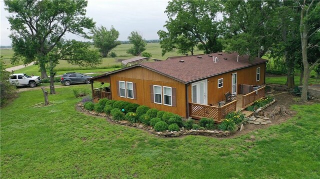 4691 New Hampshire Rd, Bronson, KS 66716 - rear view of house featuring a wooden deck, a lawn, and a shingled roof