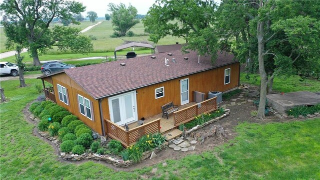4691 New Hampshire Rd, Bronson, KS 66716 - back of property featuring a deck, roof with shingles, cooling unit, and a yard