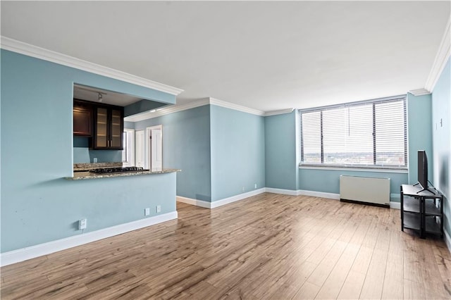 700 E 8th St Unit 11T, Kansas City, MO 64106 - unfurnished living room with ornamental molding, baseboards, and wood finished floors
