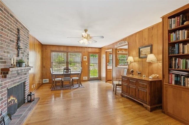 5407 W 64th Ter, Prairie Village, KS 66208 - sitting room with a ceiling fan, light wood-style floors, wood walls, and a brick fireplace