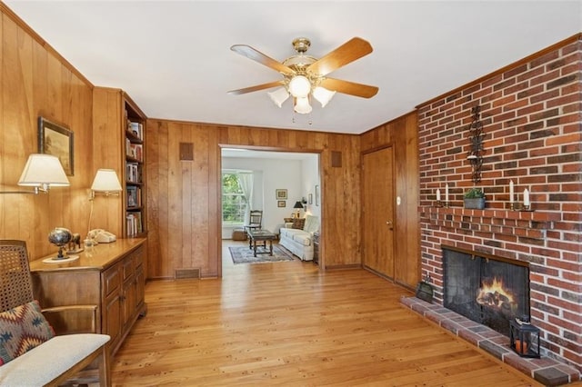 5407 W 64th Ter, Prairie Village, KS 66208 - living room with wooden walls, ceiling fan, light wood-style floors, and a fireplace