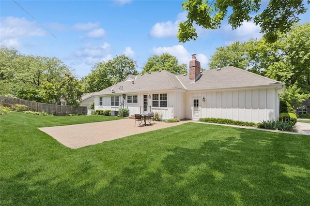 5407 W 64th Ter, Prairie Village, KS 66208 - back of house with board and batten siding, a chimney, a patio area, and a shingled roof