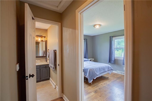 7610 NE Bacon Rd, Cameron, MO 64429 - bedroom featuring connected bathroom, light wood-type flooring, and baseboards