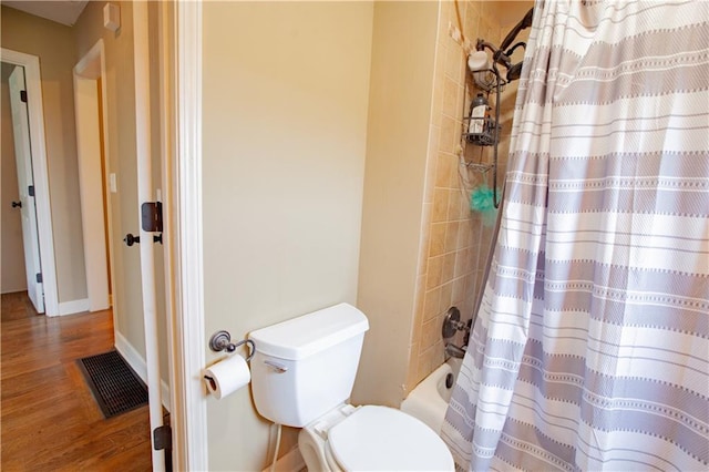 7610 NE Bacon Rd, Cameron, MO 64429 - full bath with toilet, wood finished floors, shower / bathtub combination with curtain, and baseboards