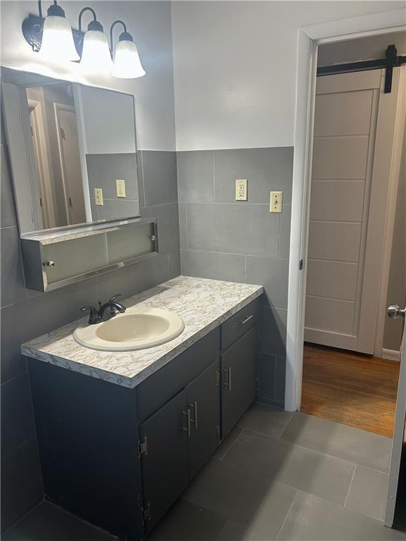 1923 Seneca St, Leavenworth, KS 66048 - bathroom featuring tile walls and vanity