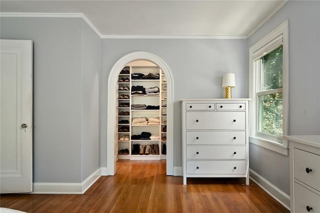 35 W 70th St, Kansas City, MO 64113 - bedroom featuring a spacious closet, ornamental molding, dark wood-style floors, a closet, and arched walkways