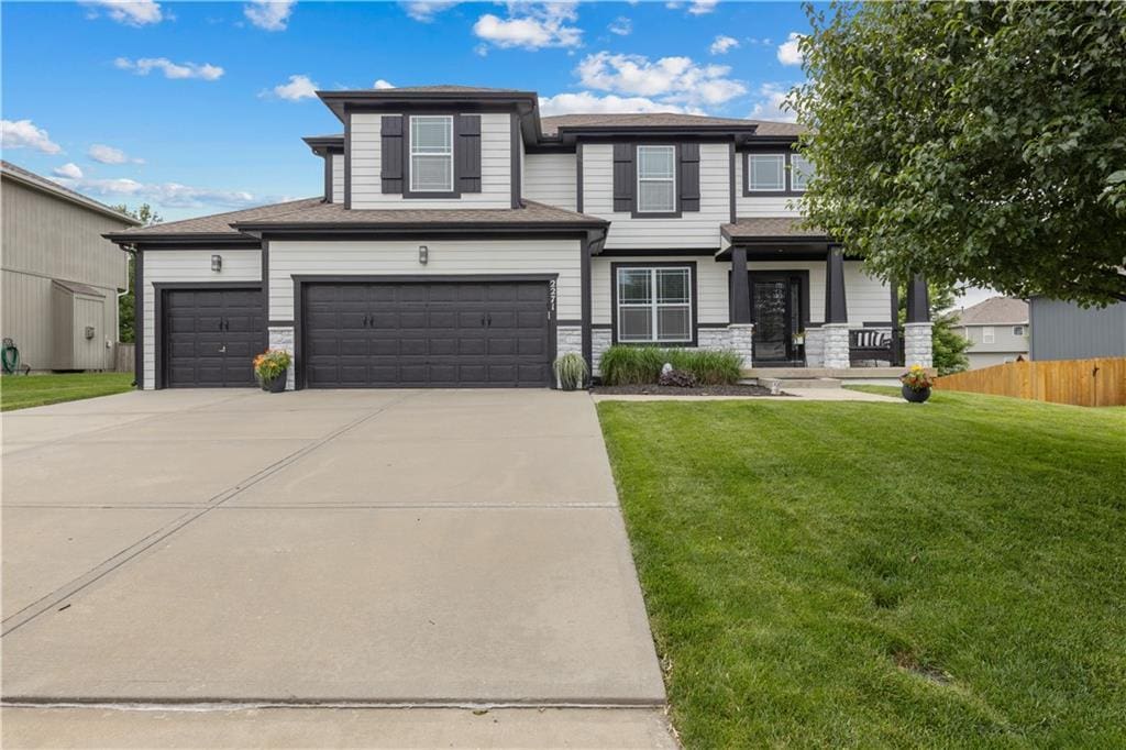 2271 W Loula St, Olathe, KS 66061 - view of front of house with driveway, stone siding, and a garage