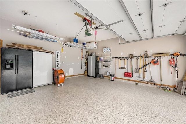 15417 Poplar St, Basehor, KS 66007 - garage featuring black fridge, freestanding refrigerator, and a garage door opener