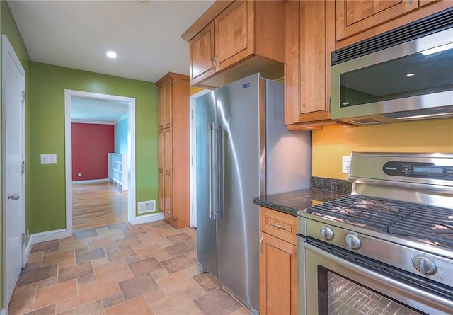 8811 W 66th Ter, Mission, KS 66202 - kitchen featuring appliances with stainless steel finishes, stone finish floors, baseboards, brown cabinetry, and recessed lighting