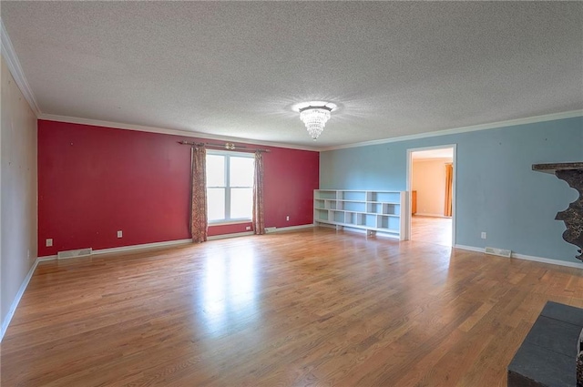 8811 W 66th Ter, Mission, KS 66202 - unfurnished living room featuring ornamental molding, a textured ceiling, wood finished floors, and baseboards