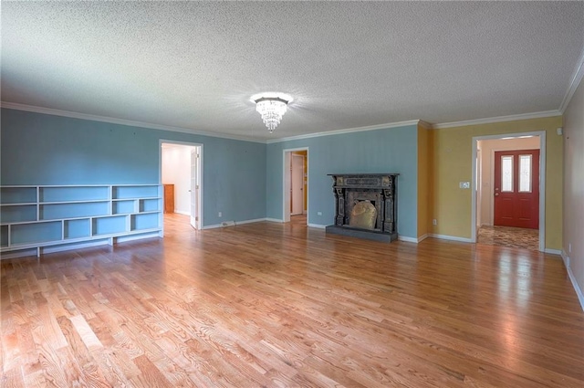 8811 W 66th Ter, Mission, KS 66202 - unfurnished living room featuring light wood finished floors, a textured ceiling, ornamental molding, baseboards, and a fireplace with raised hearth