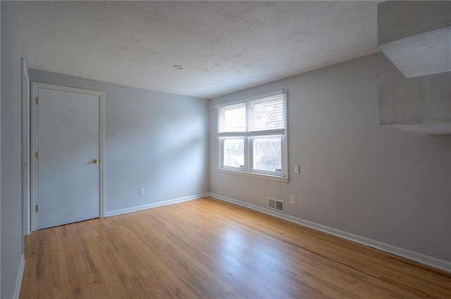 8811 W 66th Ter, Mission, KS 66202 - unfurnished room with wood finished floors, a textured ceiling, and baseboards