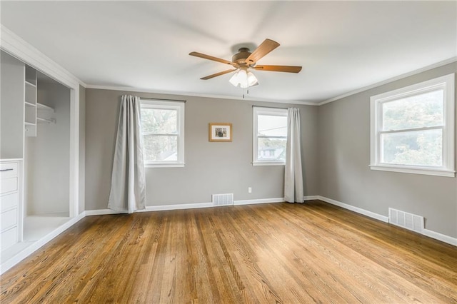 10100 E Sheley Rd, Independence, MO 64052 - unfurnished bedroom featuring multiple windows, wood finished floors, crown molding, baseboards, and a closet