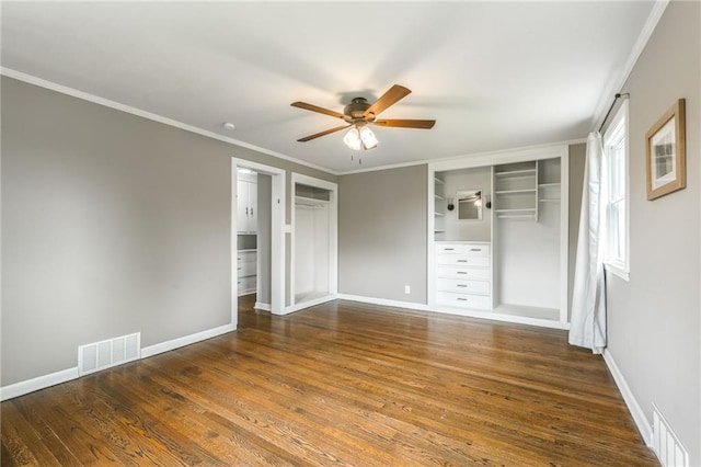 10100 E Sheley Rd, Independence, MO 64052 - unfurnished bedroom featuring wood finished floors, crown molding, baseboards, ceiling fan, and multiple closets