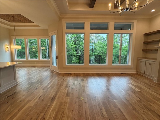 22428 W 90th Ter, Lenexa, KS 66227 - interior space featuring a chandelier, a tray ceiling, wood finished floors, crown molding, and baseboards