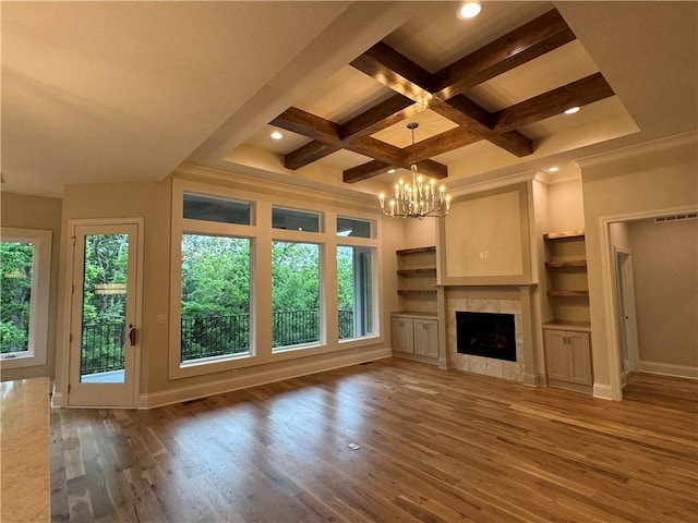 22428 W 90th Ter, Lenexa, KS 66227 - unfurnished living room featuring wood finished floors, a chandelier, coffered ceiling, beam ceiling, and a tiled fireplace