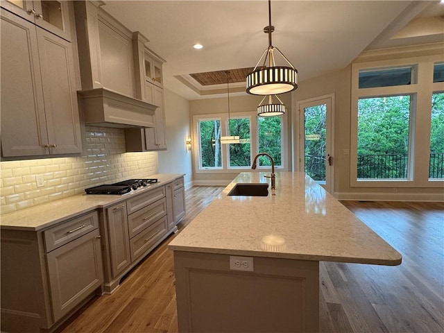 22428 W 90th Ter, Lenexa, KS 66227 - kitchen featuring stainless steel gas stovetop, a sink, wood finished floors, a raised ceiling, and recessed lighting