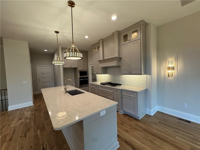 22428 W 90th Ter, Lenexa, KS 66227 - kitchen featuring baseboards, a sink, dark wood-type flooring, backsplash, and a center island with sink