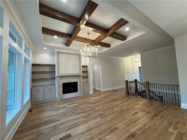 22428 W 90th Ter, Lenexa, KS 66227 - unfurnished living room with light wood-type flooring, coffered ceiling, beamed ceiling, a chandelier, and baseboards