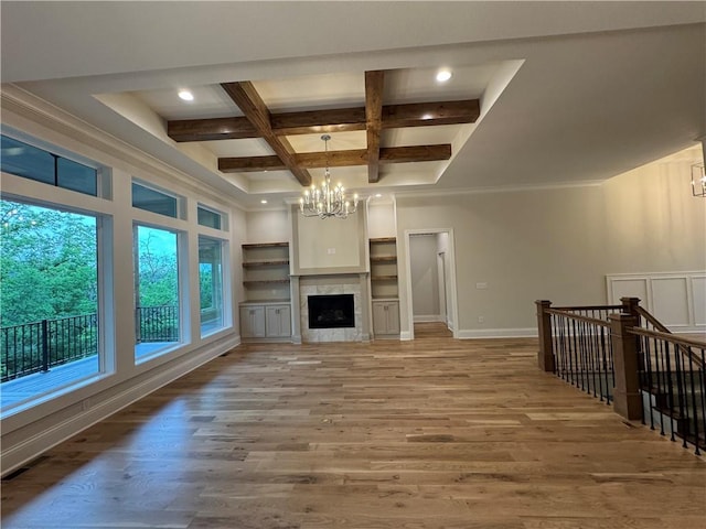 22428 W 90th Ter, Lenexa, KS 66227 - unfurnished living room featuring a chandelier, beamed ceiling, light wood finished floors, coffered ceiling, and recessed lighting