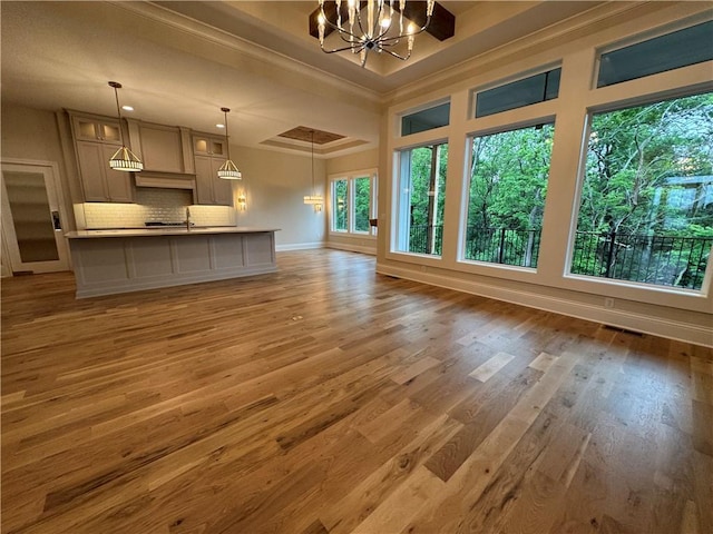 22428 W 90th Ter, Lenexa, KS 66227 - unfurnished living room featuring a chandelier, crown molding, light wood finished floors, and baseboards
