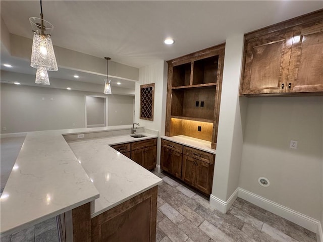 22428 W 90th Ter, Lenexa, KS 66227 - kitchen with a sink, a peninsula, pendant lighting, baseboards, and light stone countertops