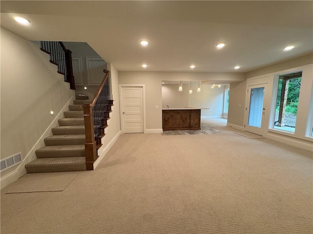22428 W 90th Ter, Lenexa, KS 66227 - unfurnished living room with bar with sink, stairs, light carpet, recessed lighting, and baseboards
