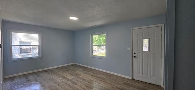 2918 S 52nd Ter, Kansas City, KS 66106 - entrance foyer featuring wood finished floors, a textured ceiling, and baseboards