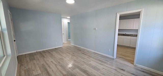2918 S 52nd Ter, Kansas City, KS 66106 - empty room featuring light wood-style flooring, baseboards, and a sink
