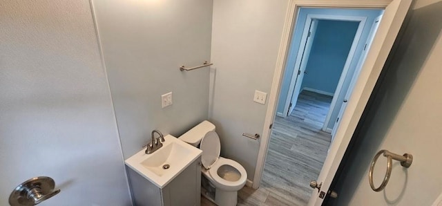 2918 S 52nd Ter, Kansas City, KS 66106 - half bathroom featuring toilet, wood finished floors, vanity, and baseboards