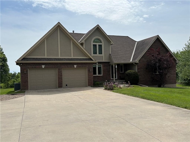 2819 S Dillingham Rd, Grain Valley, MO 64029 - view of front of home featuring stucco siding, concrete driveway, a front lawn, and brick siding