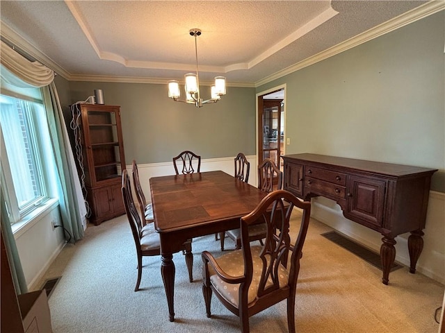 2819 S Dillingham Rd, Grain Valley, MO 64029 - dining room with a tray ceiling, light colored carpet, a chandelier, crown molding, and a textured ceiling