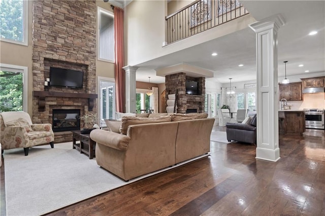 24901 W 91st Pl, Lenexa, KS 66227 - living room featuring a fireplace, ornate columns, dark wood-style floors, recessed lighting, and a high ceiling