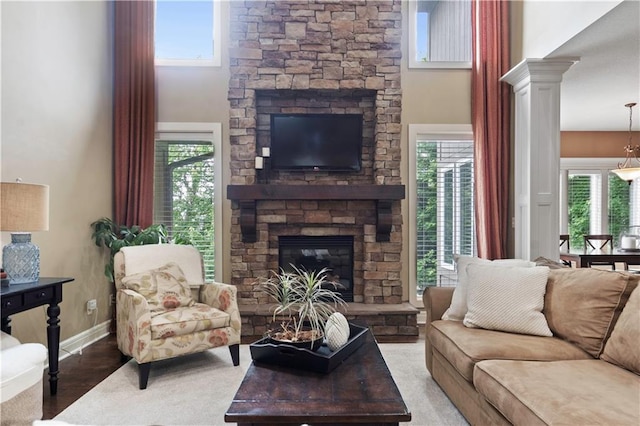 24901 W 91st Pl, Lenexa, KS 66227 - living area with a stone fireplace, a high ceiling, ornate columns, and baseboards