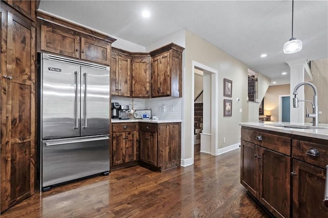 24901 W 91st Pl, Lenexa, KS 66227 - kitchen featuring built in refrigerator, a sink, dark wood-style floors, light countertops, and decorative backsplash