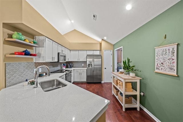 2051 W 139th Ter, Leawood, KS 66224 - kitchen featuring appliances with stainless steel finishes, tasteful backsplash, lofted ceiling, dark wood-style flooring, and light stone counters