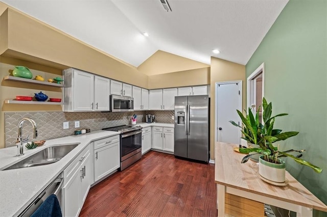 2051 W 139th Ter, Leawood, KS 66224 - kitchen with appliances with stainless steel finishes, vaulted ceiling, dark wood-style floors, decorative backsplash, and white cabinetry