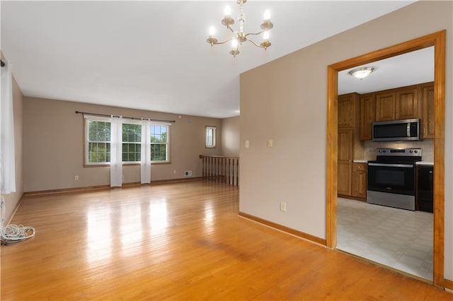 210 Murray Rd, Lees Summit, MO 64081 - unfurnished living room with a chandelier, light wood-style flooring, and baseboards