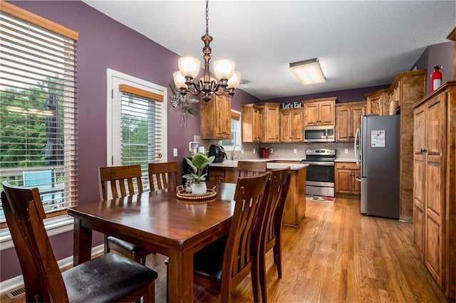 4422 N 122nd Ter, Kansas City, KS 66109 - dining space featuring light wood-style flooring and a chandelier