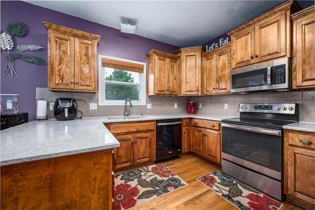 4422 N 122nd Ter, Kansas City, KS 66109 - kitchen featuring appliances with stainless steel finishes, a sink, a peninsula, light wood finished floors, and light countertops