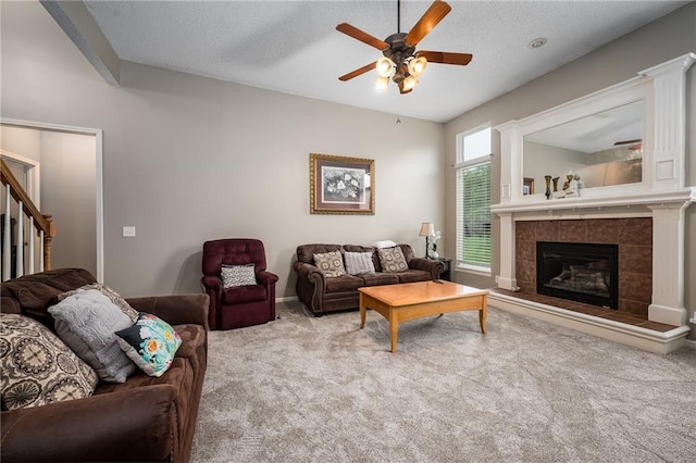 4422 N 122nd Ter, Kansas City, KS 66109 - living room with carpet flooring, a ceiling fan, a tile fireplace, stairway, and a textured ceiling