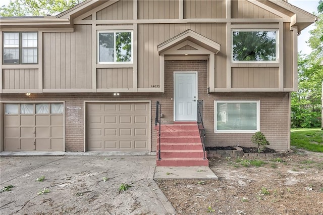 14033 Dornoch St, Grandview, MO 64030 - split foyer home with brick siding, concrete driveway, and an attached garage