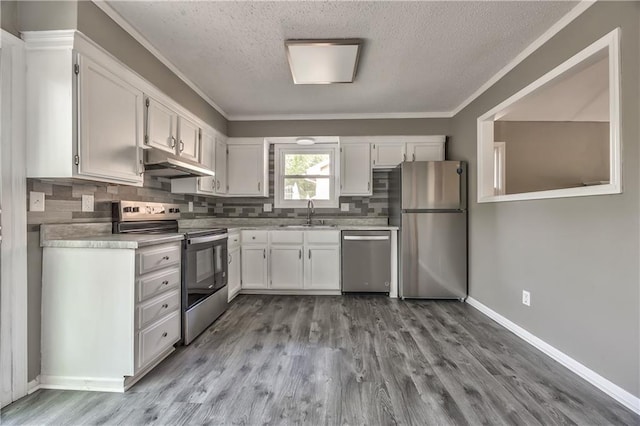 14033 Dornoch St, Grandview, MO 64030 - kitchen featuring stainless steel appliances, under cabinet range hood, a textured ceiling, a sink, and wood finished floors