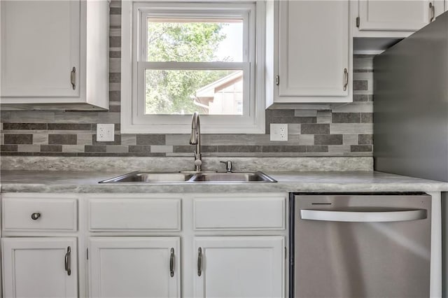 14033 Dornoch St, Grandview, MO 64030 - kitchen with stainless steel dishwasher, a sink, white cabinetry, and decorative backsplash