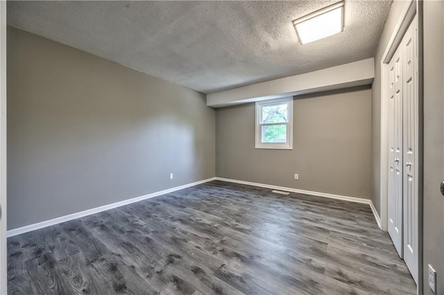 14033 Dornoch St, Grandview, MO 64030 - empty room featuring a textured ceiling, dark wood-style flooring, and baseboards